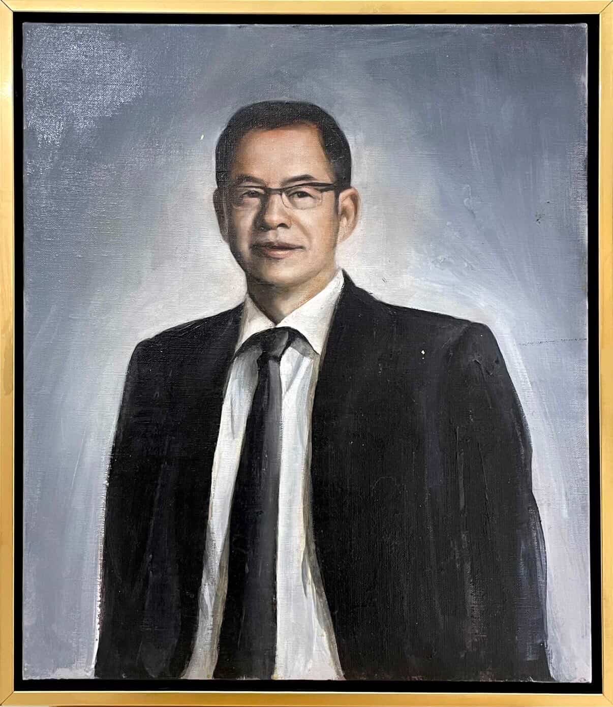 Waist-up portrait of a man in a dark suit and glasses.